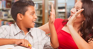 LC-elementary-student-boy-reading-studying-giving-teacher-high-five.jpg