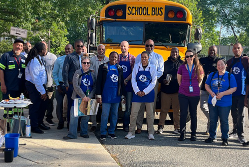 M-Wise Staff in front of bus.png